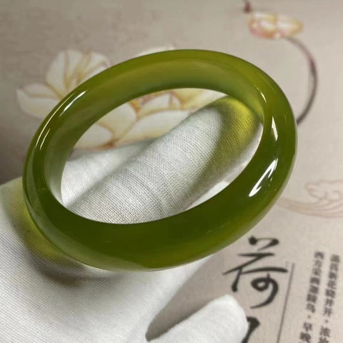 Gelang Giok Cui Alami Berpendar dan tembus cahaya Ukuran 57-59mm Lebar 13.3mm Giok terbentuk secara alami Pola acak Pengiriman dan pajak sudah termasuk.