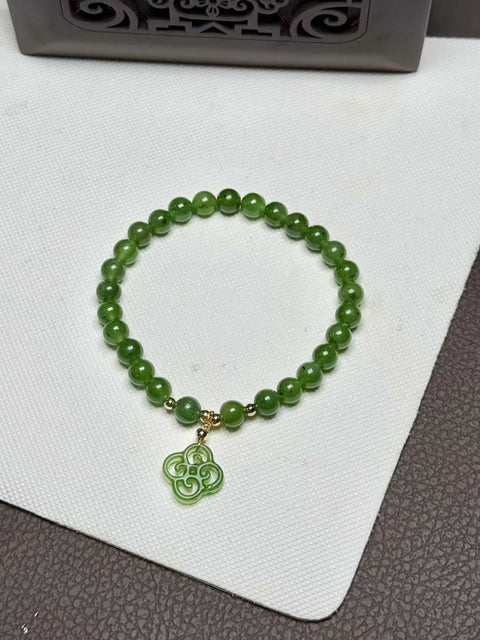 Gelang Kiwi Giok Hetian berwarna hijau zamrud yang rimbun dengan ukiran tangan semanggi keberuntungan yang melambangkan keberuntungan. Ukurannya sekitar 6 mm. Biaya kirim dan pajak sudah termasuk.
