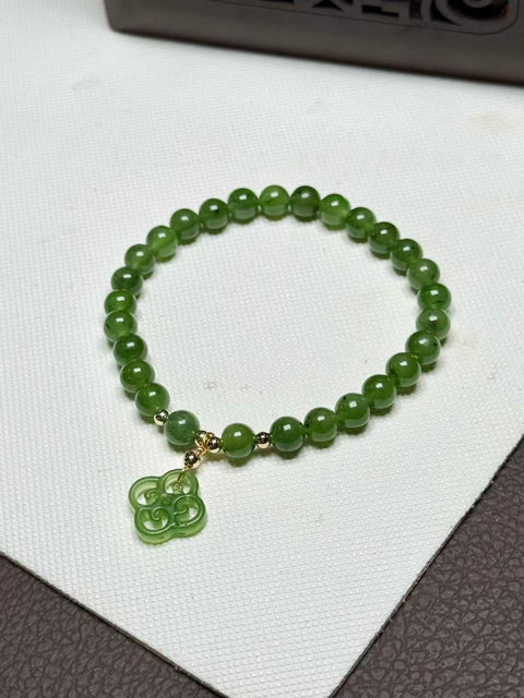 Gelang Kiwi Giok Hetian berwarna hijau zamrud yang rimbun dengan ukiran tangan semanggi keberuntungan yang melambangkan keberuntungan. Ukurannya sekitar 6 mm. Biaya kirim dan pajak sudah termasuk.
