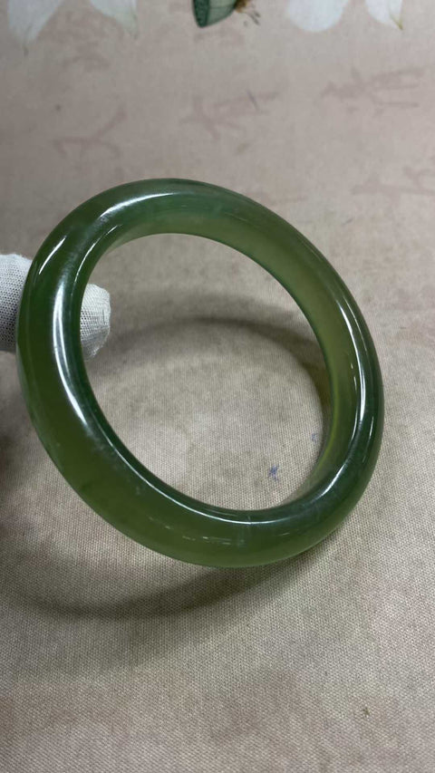 Gelang giok Xiuyan yang indah, berwarna hijau penuh dengan zamrud yang mengambang, melambangkan kekayaan dan kemakmuran seumur hidup. Diameter dalam: 64,2 mm, lebar tepi: 12 mm. Semua batu terbentuk secara alami. Biaya pengiriman dan pajak sudah termasuk.