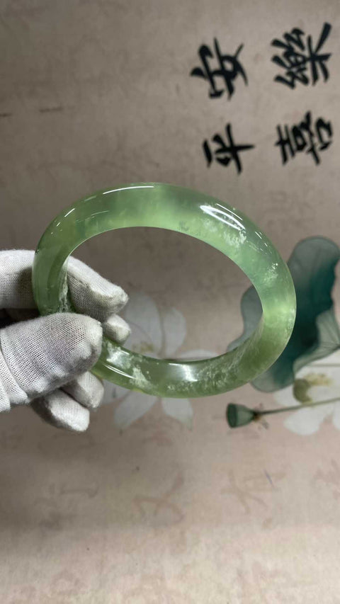 Gelang giok Xiuyan yang indah, berwarna hijau es dengan zamrud yang mengambang, melambangkan kekayaan dan kemakmuran seumur hidup. Diameter dalam: 65,5 mm, lebar tepi: 13,6 mm. Semua batu terbentuk secara alami. Biaya pengiriman dan pajak sudah termasuk.