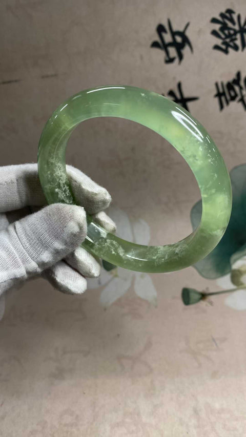 Gelang giok Xiuyan yang indah, berwarna hijau es dengan zamrud yang mengambang, melambangkan kekayaan dan kemakmuran seumur hidup. Diameter dalam: 65,5 mm, lebar tepi: 13,6 mm. Semua batu terbentuk secara alami. Biaya pengiriman dan pajak sudah termasuk.