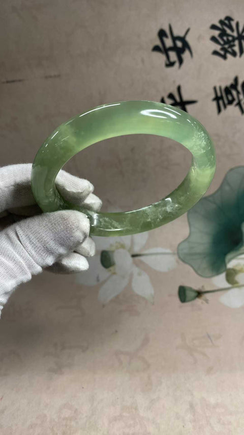 Gelang giok Xiuyan yang indah, berwarna hijau es dengan zamrud yang mengambang, melambangkan kekayaan dan kemakmuran seumur hidup. Diameter dalam: 65,5 mm, lebar tepi: 13,6 mm. Semua batu terbentuk secara alami. Biaya pengiriman dan pajak sudah termasuk.