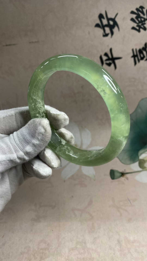 Gelang giok Xiuyan yang indah, berwarna hijau es dengan zamrud yang mengambang, melambangkan kekayaan dan kemakmuran seumur hidup. Diameter dalam: 65,5 mm, lebar tepi: 13,6 mm. Semua batu terbentuk secara alami. Biaya pengiriman dan pajak sudah termasuk.