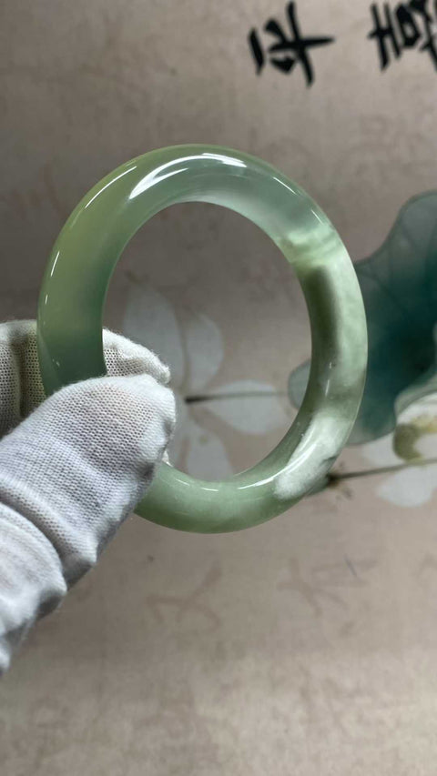 Gelang giok Xiuyan yang indah dengan rona hijau es dan zamrud yang berkilau, melambangkan kekayaan dan kemakmuran seumur hidup. Diameter dalam: 55,6 mm, lebar samping: 12,3 mm. Semua batu terbentuk secara alami. Biaya pengiriman dan pajak sudah termasuk.