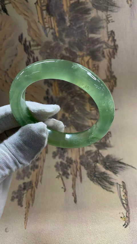 Gelang giok Xiuyan yang indah, berwarna hijau es dengan zamrud yang mengambang, melambangkan kekayaan dan kemakmuran seumur hidup. Diameter dalam: 58 mm, lebar tepi: 12,6 mm. Semua batu terbentuk secara alami. Biaya pengiriman dan pajak sudah termasuk.