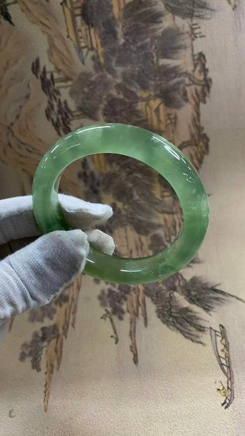 Gelang giok Xiuyan yang indah, berwarna hijau es dengan zamrud yang mengambang, melambangkan kekayaan dan kemakmuran seumur hidup. Diameter dalam: 58 mm, lebar tepi: 12,6 mm. Semua batu terbentuk secara alami. Biaya pengiriman dan pajak sudah termasuk.