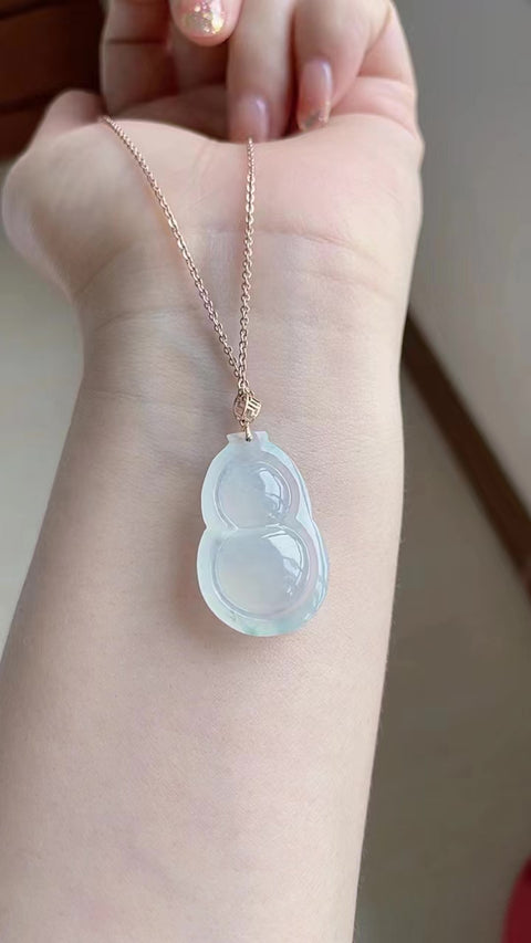 Labu jadeit alami, melambangkan keberuntungan dan kemakmuran. Jadeit ini memiliki butiran yang sangat halus, tembus cahaya, dan tampak bening sedingin es. Berlapis emas 18 karat. Ukuran: 2,8 x 1,8 cm. Biaya pengiriman dan pajak sudah termasuk.