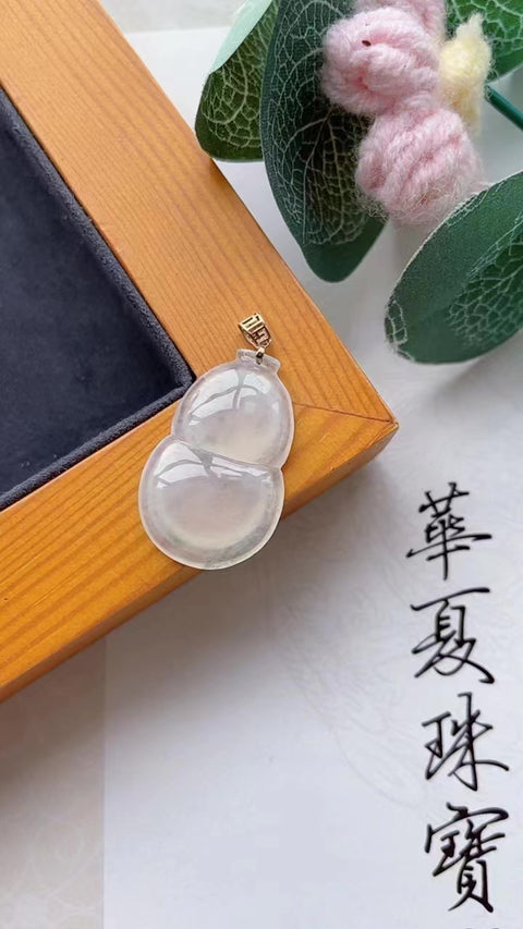 Labu jadeit alami, melambangkan keberuntungan dan kemakmuran. Jadeit ini memiliki butiran yang sangat halus, tembus cahaya, dan tampak bening sedingin es. Berlapis emas 18 karat. Ukuran: 2,8 x 1,8 cm. Biaya pengiriman dan pajak sudah termasuk.