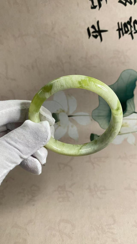 Gelang tangan dari batu giok hijau dengan lapisan susu, diameter 65,2 mm, lebar tepi 13,5 mm. Batu alam ini terbentuk secara alami, sehingga pola warnanya acak. Termasuk biaya pengiriman dan pajak.