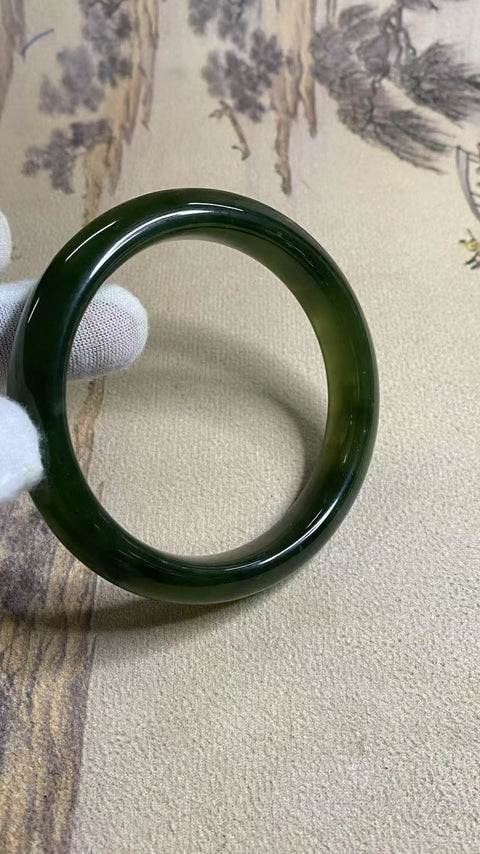 Gelang tangan besar berbahan giok Xiuyan berwarna hijau tua, diameter 68mm, lebar tepi 12,7mm. Batu alam ini terbentuk secara alami, pola motifnya acak. Termasuk biaya pengiriman dan pajak.