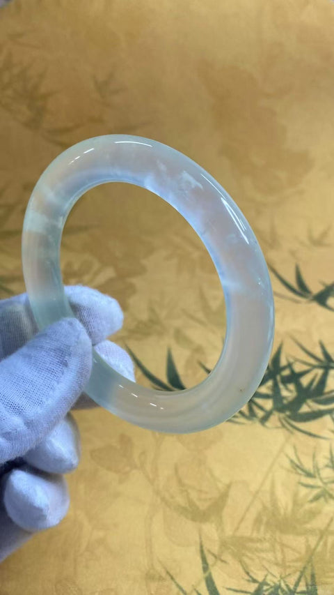 Gelang tangan berbentuk lingkaran tebal dari batu giok Xiu Yu jenis es, transparan seperti es, bulat dan halus, diameter 56,8 mm, ketebalan 10,3 mm. Batu alam ini terbentuk secara alami, pola dan coraknya acak. Termasuk biaya pengiriman dan pajak.