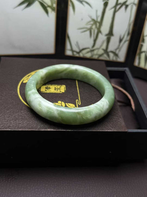 Gelang giok Xiuyan alami dengan desain busa susu rasa matcha. Perkiraan dimensi: 62,8×15×10mm. Semua batu terbentuk secara alami. Harga sudah termasuk ongkos kirim dan pajak.