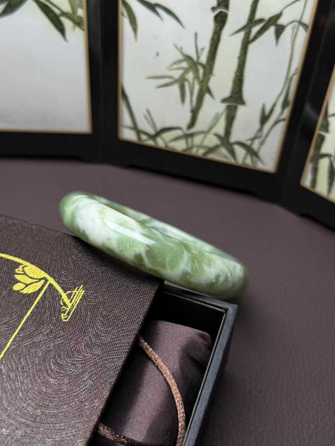Gelang giok Xiuyan alami dengan desain busa susu rasa matcha. Perkiraan dimensi: 62,8×15×10mm. Semua batu terbentuk secara alami. Harga sudah termasuk ongkos kirim dan pajak.