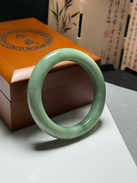 Gelang giok Xiuyan, berwarna hijau kacang dan krem, dengan jimat keberuntungan, berukuran sekitar 54mm. Semua batu terbentuk secara alami. Harga sudah termasuk ongkos kirim dan pajak.