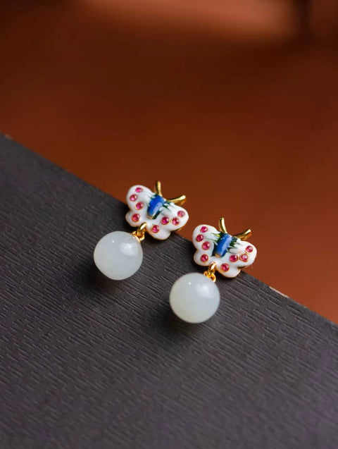 Kupu-kupu enamel, dengan kelopaknya berkilauan berlian merah muda, dihiasi dengan manik giok putih berkilau yang bergoyang lembut. Nomor Barang: 202603101323