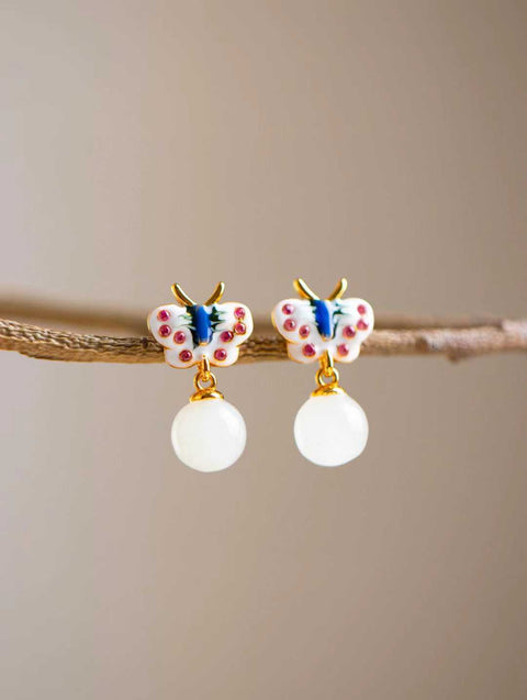 Kupu-kupu enamel, dengan kelopaknya berkilauan berlian merah muda, dihiasi dengan manik giok putih berkilau yang bergoyang lembut. Nomor Barang: 202603101323