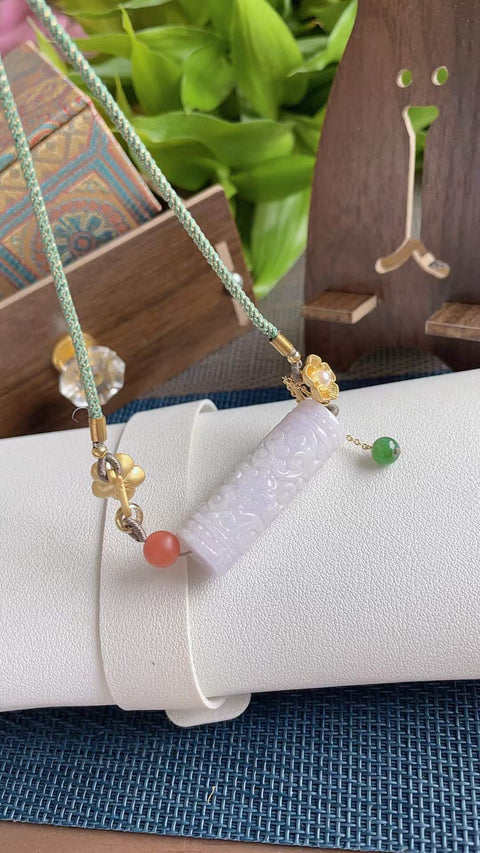 Liontin giok alami, melambangkan kekayaan berlimpah. Gioknya halus dan berkilau, dengan transparansi yang sangat baik. Memiliki rona ungu muda dan ukiran yang indah. Dimensi: 4,0 x 1,2 cm. Harga sudah termasuk ongkos kirim dan pajak.