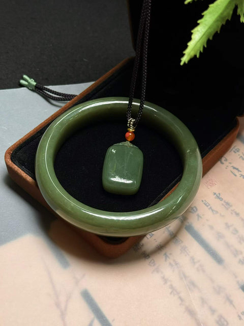 Giok Hetian dengan tekstur kuning kehijauan, meningkatkan keputihan dan keanggunan. Set dua buah, perkiraan dimensi: Diameter dalam gelang 55-62mm, Liontin 28×19mm.
