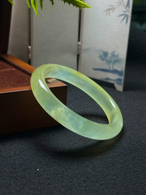 Gelang giok Xiuyan alami dan tembus cahaya ini berukuran sekitar 59,6 x 12 x 8,6 mm. Semua batu terbentuk secara alami. Harga sudah termasuk ongkos kirim dan pajak.