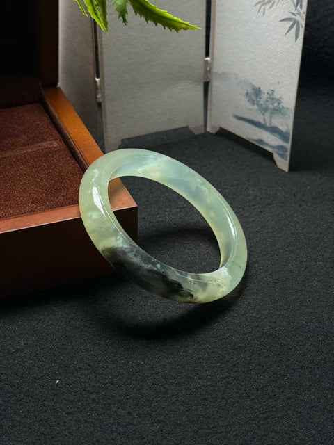 Gelang giok Xiuyan alami dan tembus cahaya ini berukuran sekitar 56,5 x 12,3 x 9,3 mm. Semua batu terbentuk secara alami. Harga sudah termasuk ongkos kirim dan pajak.