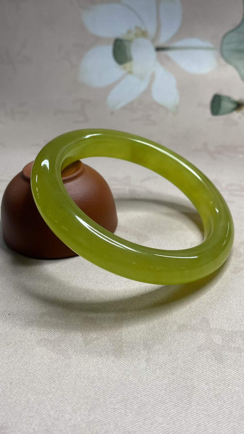 Gelang giok Xiuyan yang indah, berwarna hijau kekuningan. Diameter dalam: 60,3 mm, lebar tepi: 11,5 mm. Semua batu terbentuk secara alami. Harga sudah termasuk ongkos kirim dan pajak.