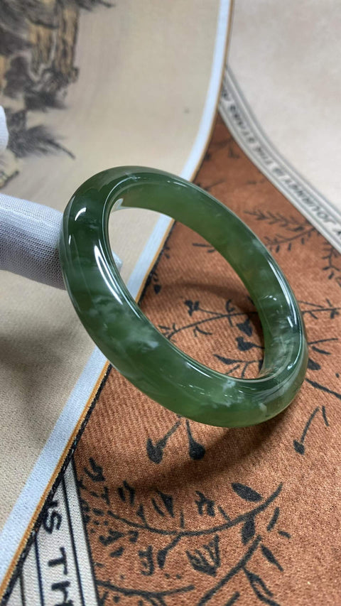Gelang giok Xiuyan yang sangat indah, berwarna hijau pekat dengan zamrud mengambang, diameter dalam 58,2 mm, lebar samping 12,8 mm. Semua batu terbentuk secara alami. Harga sudah termasuk ongkos kirim dan pajak.