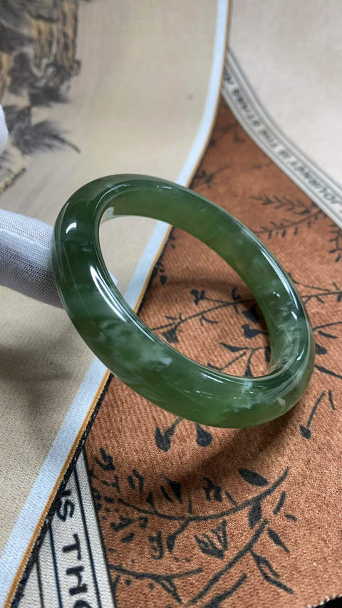 Gelang giok Xiuyan yang sangat indah, berwarna hijau pekat dengan zamrud mengambang, diameter dalam 58,2 mm, lebar samping 12,8 mm. Semua batu terbentuk secara alami. Harga sudah termasuk ongkos kirim dan pajak.