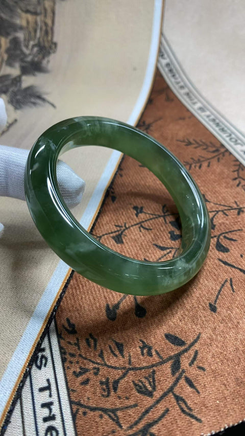 Gelang giok Xiuyan yang sangat indah, berwarna hijau pekat dengan zamrud mengambang, diameter dalam 58,2 mm, lebar samping 12,8 mm. Semua batu terbentuk secara alami. Harga sudah termasuk ongkos kirim dan pajak.