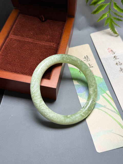 Gelang giok Xiuyan alami dengan desain bunga yang halus dan elegan. Perkiraan dimensi: 60-10,3-10,3 mm. Semua batu terbentuk secara alami. Termasuk ongkos kirim dan pajak.