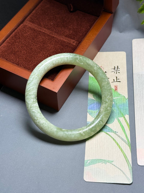 Gelang giok Xiuyan alami dengan desain bunga yang halus dan elegan. Perkiraan dimensi: 60-10,3-10,3 mm. Semua batu terbentuk secara alami. Termasuk ongkos kirim dan pajak.
