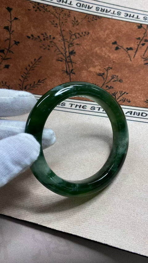 Gelang giok Xiuyan yang indah, berwarna hijau pekat dengan zamrud yang berkilauan, melambangkan kekayaan dan kemakmuran seumur hidup. Diameter dalam: 60 mm, lebar tepi: 12,7 mm. Semua batu terbentuk secara alami. Termasuk ongkos kirim dan pajak.