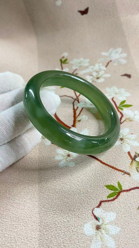 Gelang giok Xiuyan yang indah, berwarna hijau pekat dengan zamrud yang berkilauan, melambangkan kekayaan dan kemakmuran seumur hidup. Diameter dalam: 58,5 mm, lebar tepi: 12,7 mm. Semua batu terbentuk secara alami. Termasuk ongkos kirim dan pajak.