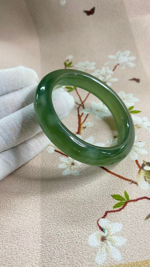 Gelang giok Xiuyan yang indah, berwarna hijau pekat dengan zamrud yang berkilauan, melambangkan kekayaan dan kemakmuran seumur hidup. Diameter dalam: 58,5 mm, lebar tepi: 12,7 mm. Semua batu terbentuk secara alami. Termasuk ongkos kirim dan pajak.