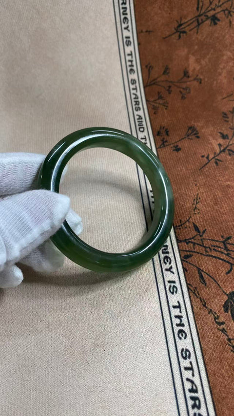 Gelang giok Xiuyan yang indah, berwarna hijau pekat dengan zamrud yang berkilauan, melambangkan kekayaan dan kemakmuran seumur hidup. Diameter dalam: 58 mm, lebar tepi: 11 mm. Semua batu terbentuk secara alami. Termasuk ongkos kirim dan pajak.