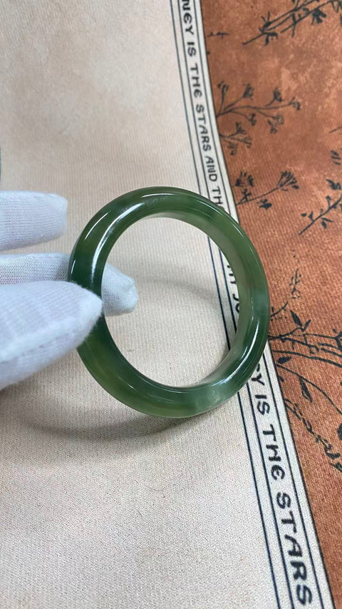 Gelang giok Xiuyan yang indah, berwarna hijau pekat dengan zamrud yang berkilauan, melambangkan kekayaan dan kemakmuran seumur hidup. Diameter dalam: 58 mm, lebar tepi: 11 mm. Semua batu terbentuk secara alami. Termasuk ongkos kirim dan pajak.