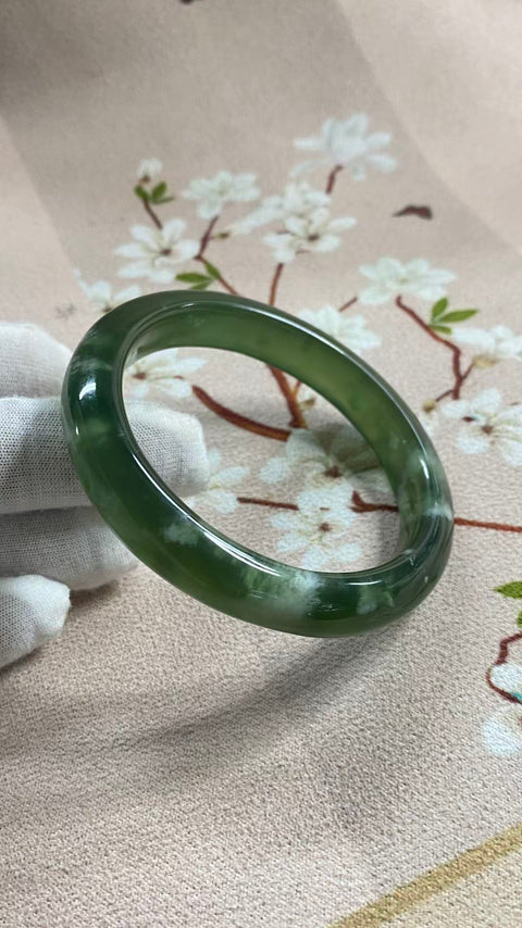 Gelang giok Xiuyan yang indah, berwarna hijau pekat dengan zamrud yang berkilauan, melambangkan kekayaan dan kemakmuran seumur hidup. Diameter dalam: 60,3 mm, lebar tepi: 11,7 mm. Semua batu terbentuk secara alami. Termasuk ongkos kirim dan pajak.