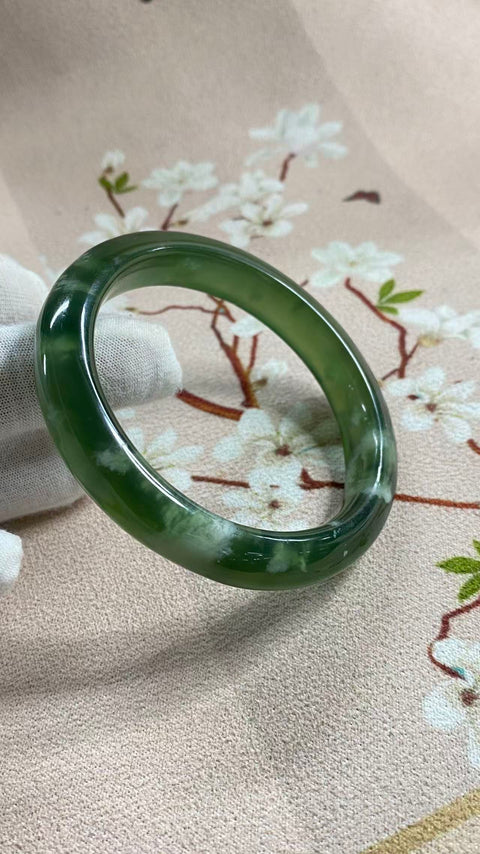 Gelang giok Xiuyan yang indah, berwarna hijau pekat dengan zamrud yang berkilauan, melambangkan kekayaan dan kemakmuran seumur hidup. Diameter dalam: 60,3 mm, lebar tepi: 11,7 mm. Semua batu terbentuk secara alami. Termasuk ongkos kirim dan pajak.