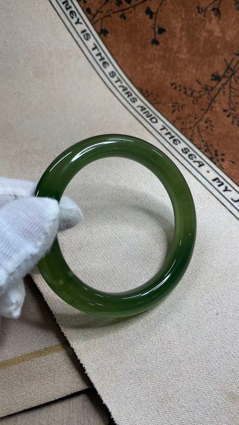 Gelang giok Xiuyan yang indah, berwarna hijau pekat dengan zamrud yang berkilauan, melambangkan kekayaan dan kemakmuran seumur hidup. Diameter dalam: 58 mm, lebar tepi: 11 mm. Semua batu terbentuk secara alami. Harga sudah termasuk ongkos kirim dan pajak.