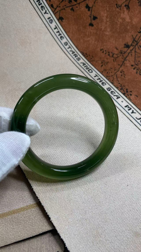 Gelang giok Xiuyan yang indah, berwarna hijau pekat dengan zamrud yang berkilauan, melambangkan kekayaan dan kemakmuran seumur hidup. Diameter dalam: 58 mm, lebar tepi: 11 mm. Semua batu terbentuk secara alami. Harga sudah termasuk ongkos kirim dan pajak.