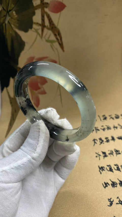 Gelang giok Xiuyan indah dengan gradasi warna – gaya lukisan tinta. Diameter dalam: 57,5 mm, lebar tepi: 11,9 mm. Harga sudah termasuk ongkos kirim dan pajak.