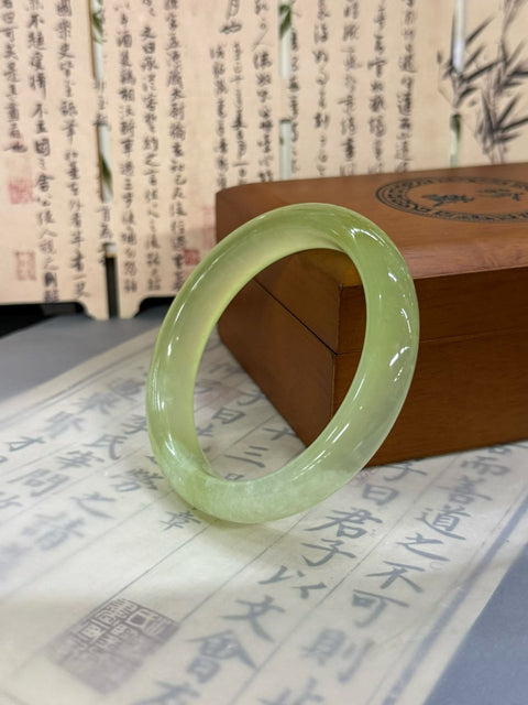 Gelang "Kedamaian" giok Xiuyan bening sebening es. Perkiraan dimensi: 56,5×12,3×8,5 mm. Harga sudah termasuk ongkos kirim dan pajak.