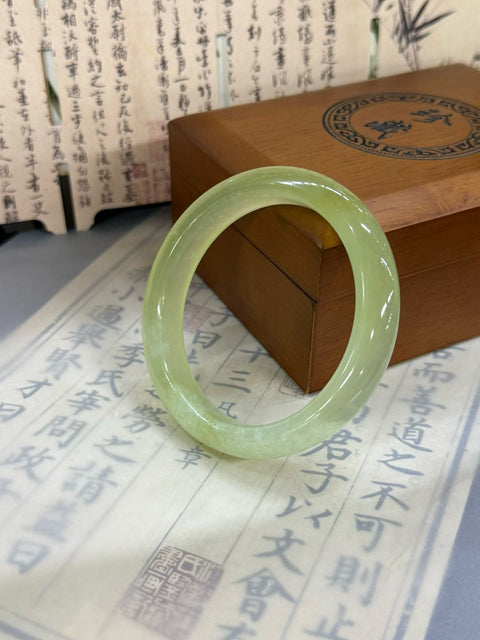 Gelang "Kedamaian" giok Xiuyan bening sebening es. Perkiraan dimensi: 56,5×12,3×8,5 mm. Harga sudah termasuk ongkos kirim dan pajak.