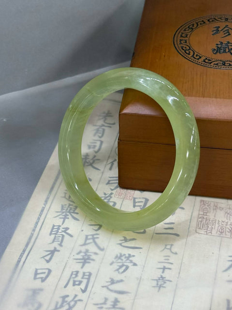 Gelang giok Xiuyan berwarna terang ini jernih dan elegan dengan warna dasar yang lembut dan halus. Dimensi: sekitar 56,5×12×8,8 mm. Harga sudah termasuk ongkos kirim dan pajak.