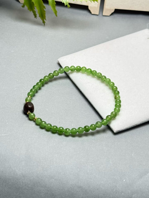 Gelang giok Hetian ini memiliki warna hijau hangat dan berkilau, serta dihiasi dengan aksen kayu gaharu. Desainnya yang sederhana membuatnya cocok untuk berbagai kesempatan. Ukuran perkiraan: 4 mm. Harga sudah termasuk ongkos kirim dan pajak.
