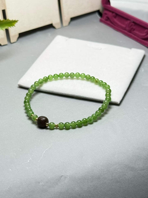 Gelang giok Hetian ini memiliki warna hijau hangat dan berkilau, serta dihiasi dengan aksen kayu gaharu. Desainnya yang sederhana membuatnya cocok untuk berbagai kesempatan. Ukuran perkiraan: 4 mm. Harga sudah termasuk ongkos kirim dan pajak.