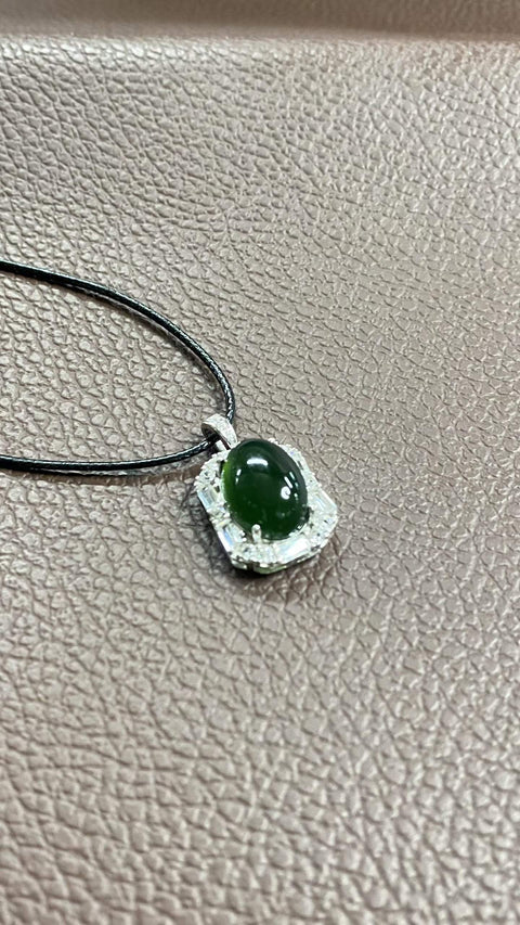 Liontin giok Xiuyan yang indah, warna hijau pekat, dipasang pada perak 925. Dimensi: 26 x 15 mm; dimensi cabochon: 10 x 14 mm. Harga sudah termasuk ongkos kirim dan pajak.