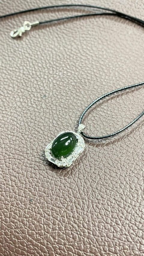 Liontin giok Xiuyan yang indah, warna hijau pekat, dipasang pada perak 925. Dimensi: 26 x 15 mm; dimensi cabochon: 10 x 14 mm. Harga sudah termasuk ongkos kirim dan pajak.