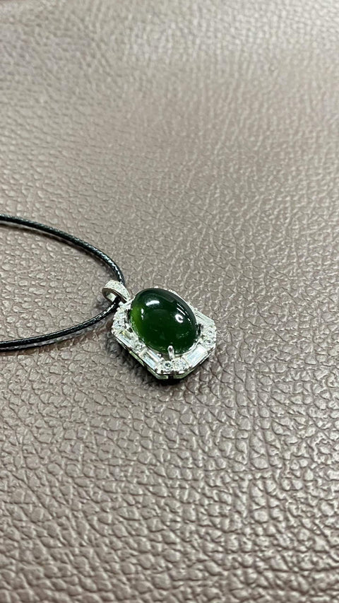 Liontin giok Xiuyan yang indah, warna hijau pekat, dipasang pada perak 925. Dimensi: 26 x 15 mm; dimensi cabochon: 10 x 14 mm. Harga sudah termasuk ongkos kirim dan pajak.