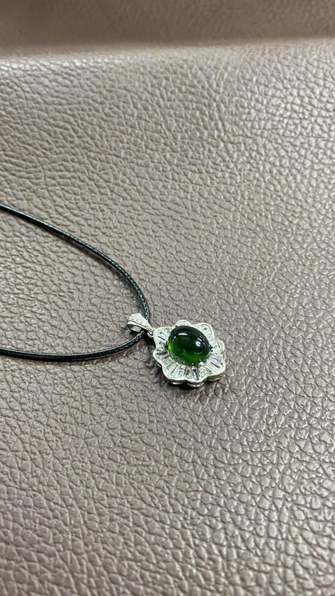 Liontin giok Xiuyan yang indah, warna hijau pekat, dipasang pada perak 925. Dimensi: 20 x 15,8 mm, dimensi cabochon: 8 x 10 mm. Harga sudah termasuk ongkos kirim dan pajak.